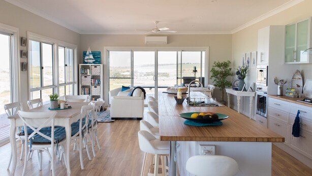 A modern kitchen with a central island, white cabinetry, and a view of the outdoors.