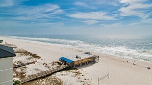 Ein Strand mit einer Rettungswache und einem Steg, der sich ins Meer erstreckt.