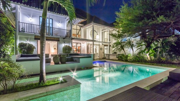 Une maison à deux étages avec une piscine, un espace extérieur aménagé et un jardin bien entretenu.