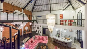 Un intérieur à plusieurs niveaux comprenant un escalier, un coin repas, un bar et une cuisine.