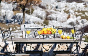 A table with a fruit bowl and glasses of orange juice, set against a snowy landscape. - Amazing home in Podgora with sauna (Podgora)