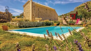A stone building with a pool, surrounded by grass and lavender. - Amazing home in Podgora with sauna (Podgora)