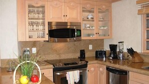 A kitchen with wooden cabinets, a stainless steel stove, a microwave, and a dishwasher.