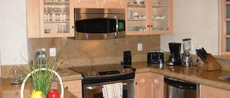 A kitchen with wooden cabinets, a stainless steel stove, a microwave, and a dishwasher.