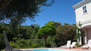 A swimming pool with white lounge chairs and a white building in the background. - La Tipasa (Tateyama)