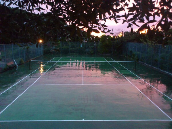 An outdoor tennis court with a net, surrounded by a fence and trees. - La Tipasa (Tateyama)