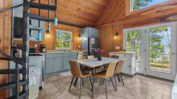 Un intérieur en bois comprenant une cuisine, un coin repas et un escalier en colimaçon.