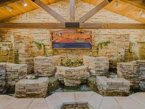 A stone-walled hot tub area with a wooden ceiling and a mural. - Great Family Condo with Golf View at Holiday Hills (Branson)