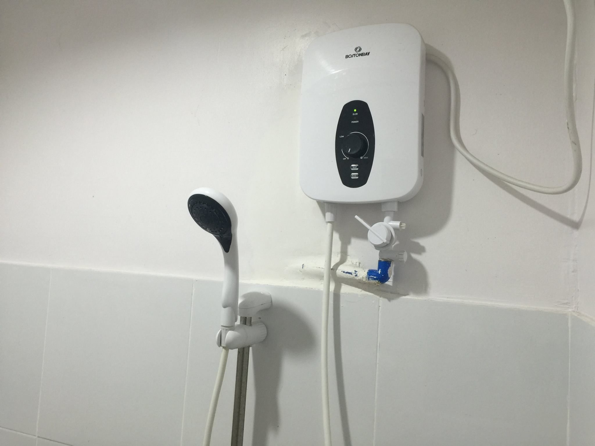 A wall-mounted shower control unit with a handheld showerhead.