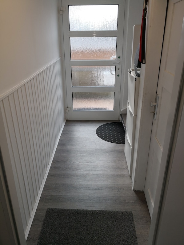A narrow hallway with a white door leading to a balcony. - very central and very quiet, apartment in the heart of Lindau (Lindau (Bodensee))