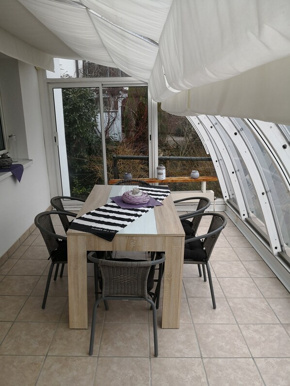 A dining area with a table set for four, surrounded by chairs, under a white canopy. - very central and very quiet, apartment in the heart of Lindau (Lindau (Bodensee))