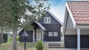 A modern house with a dark exterior, a sloped roof, and a small front porch.