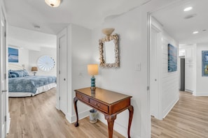 Une chambre d’hôtel avec un lit, un bureau, un miroir et une vue sur l’océan.