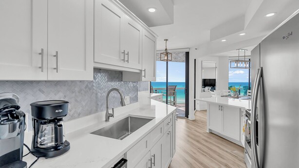 A modern kitchen with white cabinetry, a built-in dishwasher, and a coffee maker. - Free Beach Svc=2 Chairs/1 Umbrella! Awesome Views! Free Beach Bonfires M/F nts (Miramar Beach)