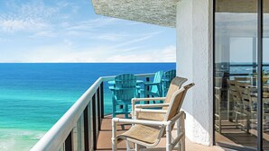 A balcony with a view of the ocean, featuring outdoor furniture and a glass door. - Free Beach Svc=2 Chairs/1 Umbrella! Awesome Views! Free Beach Bonfires M/F nts (Miramar Beach)