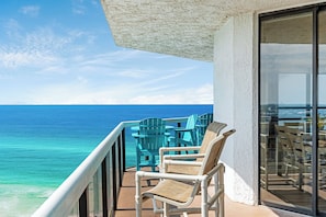 Un balcon avec vue sur l’océan, agrémenté de mobilier d’extérieur et doté d’une porte vitrée.