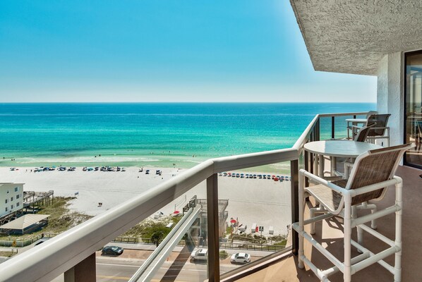 Ein Balkon mit Blick auf Strand und Meer.