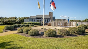 A building with a flagpole, a flag, and a fence. - GORGEOUS OCEAN FRONT MULTI LEVEL CONDOMINIUM! (Atlantic Beach)