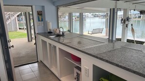 Una cocina con un ventanal grande que da a una masa de agua, un lavamanos y una encimera.