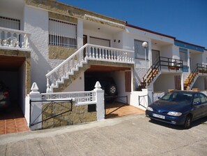 A two-story house with a garage, a staircase, and a car parked in front.