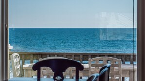 Vista desde un balcón con baranda de madera, sobre un cuerpo de agua y una estructura distante.