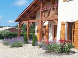 A two-story building with a wooden balcony and a covered porch. - VACATION RENTAL: VILLA BEAUTIFUL TALAIS SOULAC NEAR THE SEA (Talais)