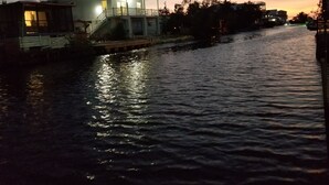 Una casa a la orilla del río con balcón y un muelle que se adentra en el agua.