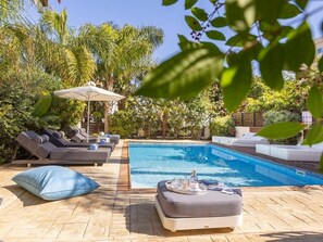 A poolside area with lounge chairs and a small table with drinks. - Villa Mylos 7 is located in the absolute center of Protaras (Protaras)