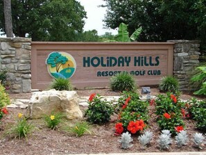 Welcome to Holiday Hills Resort & Golf Club, where a beautifully landscaped garden surrounds the entrance.