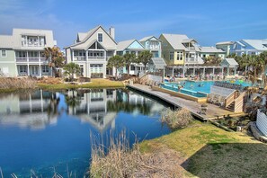 Ein Resort mit Schwimmbad, Steg und Spiegelung im Wasser.
