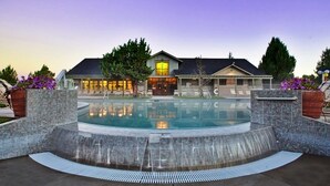 A hotel with a swimming pool, a waterfall feature, and a well-maintained garden. - Luxurious 3BR/2BA Eagle Crest Chalet on Golf Course w/ Private Hot Tub & Garage (Redmond)