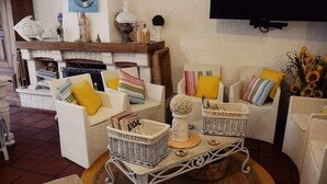 A cozy living room with white furniture, a fireplace, and decorative items. - 100 m from the ocean - 8 people (VILA NOVA DE GAIA)