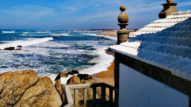 A coastal view with a stone balustrade overlooking the sea, a cross atop a building, and a clear sky. - 100 m from the ocean - 8 people (VILA NOVA DE GAIA)