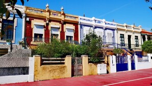 A row of colorful buildings with balconies, a red pavement, and a gate. - 100 m from the ocean - 8 people (VILA NOVA DE GAIA)