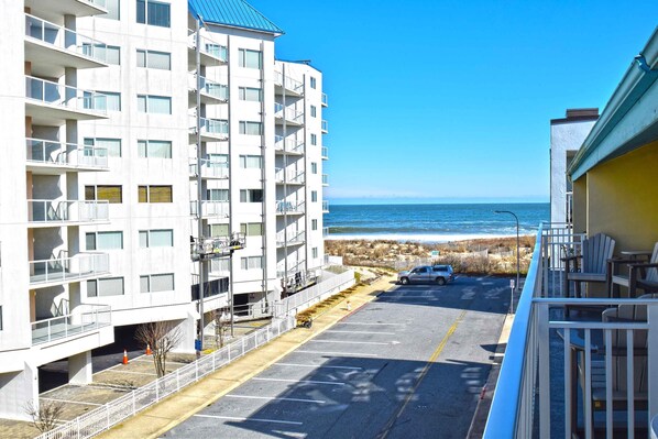 A multi-story building with balconies overlooking a beach.