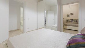 Un dormitorio con una cama grande, un armario y un espejo.