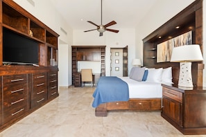A spacious bedroom with a large bed, wooden cabinetry, a ceiling fan, and a television. - Casa Bella 5BR | Unobstructed Ocean Views, Pool & Concierge (San Jose del Cabo)