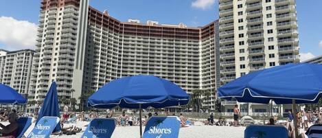 A beach with lounge chairs labeled 'Shores of Panama' and a high-rise hotel in the background.