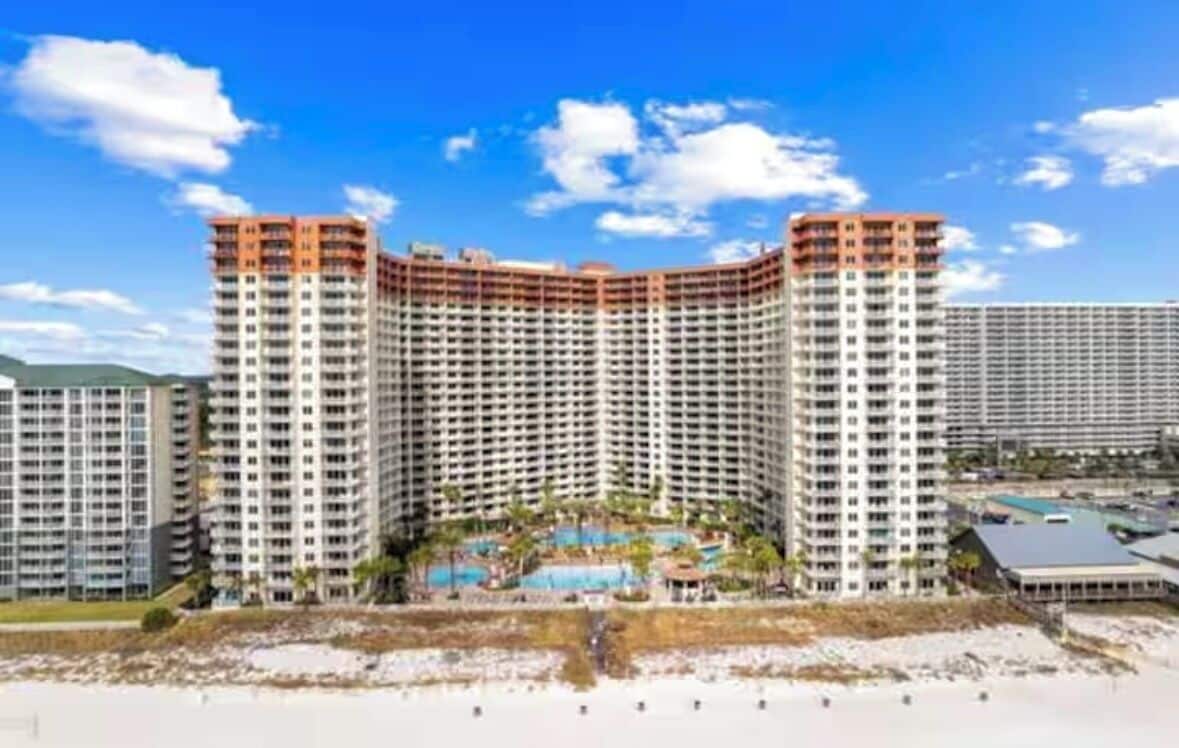 A high-rise hotel with multiple floors, a central courtyard, and a pool area.