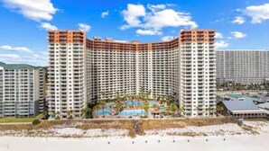 A high-rise hotel with multiple floors, a central courtyard, and a pool area. - Gulf-Front Corner Unit~Same-Floor Parking~Wrap Balcony~FREE Beach Chairs~Sleep 8 (Panama City Beach)