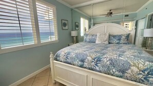 A bedroom with a bed, a ceiling fan, and a window with blinds. - Gulf-Front Corner Unit~Same-Floor Parking~Wrap Balcony~FREE Beach Chairs~Sleep 8 (Panama City Beach)