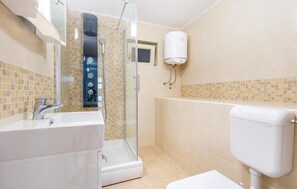 A modern bathroom with a glass-enclosed shower, a white sink, and a toilet. - 1 bedroom beautiful apartment in Matulji (Matulji)