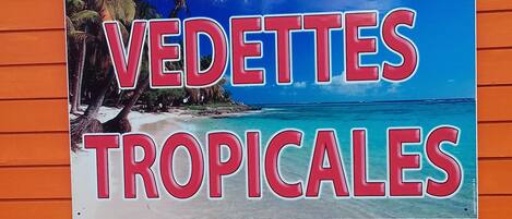 A sign with the text "BILLETERIE VEDETTES TROPICALES" on an orange wall.