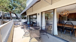 Une terrasse extérieure couverte, aménagée avec un espace repas, des chaises et une table.
