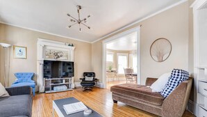 A living room with a TV, blue and brown sofas, a coffee table, and a fireplace.