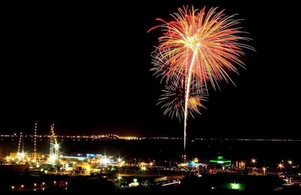 A nighttime cityscape with a prominent display of fireworks. - Beachfront Paradise at it's best!! 1/1, king, pool, hot tub, BBQ (South Padre Island)