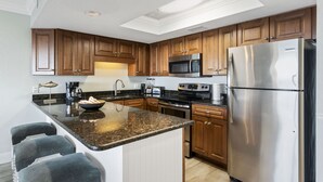 Una cocina moderna con armarios de madera, electrodomésticos de acero inoxidable y encimera de granito.