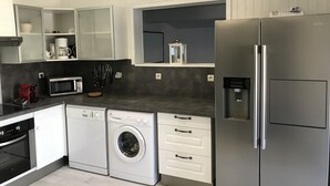 Una cocina moderna equipada con lavavajillas, lavadora, microondas y refrigerador.