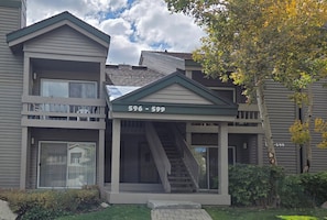 A two-story building with a central entrance, a staircase, and a small porch area. - Snowcreek Resort Vacation Rental 596 (Mammoth Lakes)