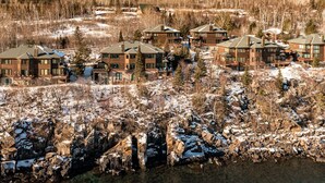 Un resort con diversi edifici, uno sfondo roccioso e una vegetazione boschiva sullo sfondo.